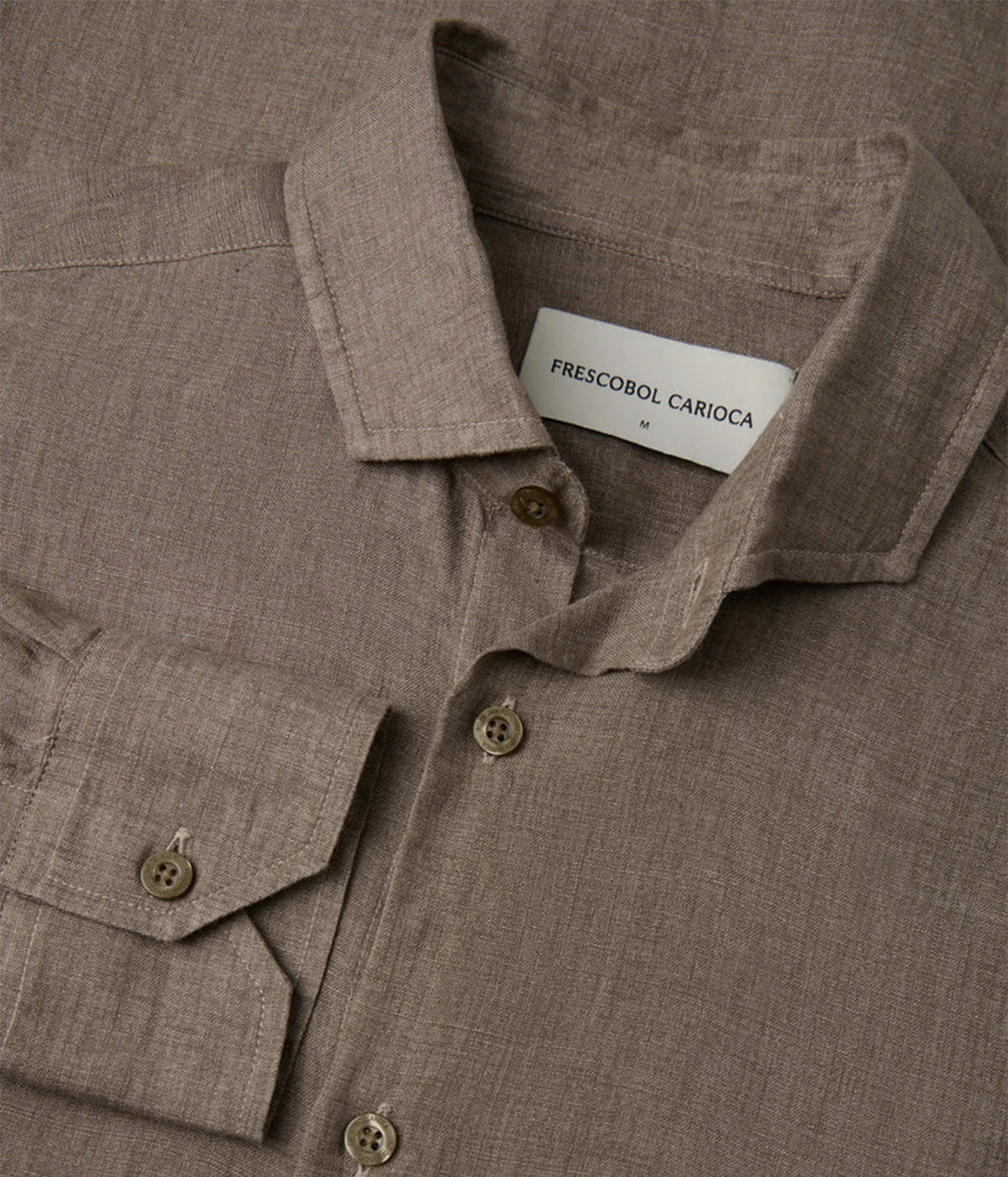 Close-up of a Frescobol Carioca Antonio Linen Long Sleeve Shirt in Dark Mink, showing the collar with a white label that reads 'FRESCOBOL CARIOCA', a buttoned chest pocket, and matching buttons.