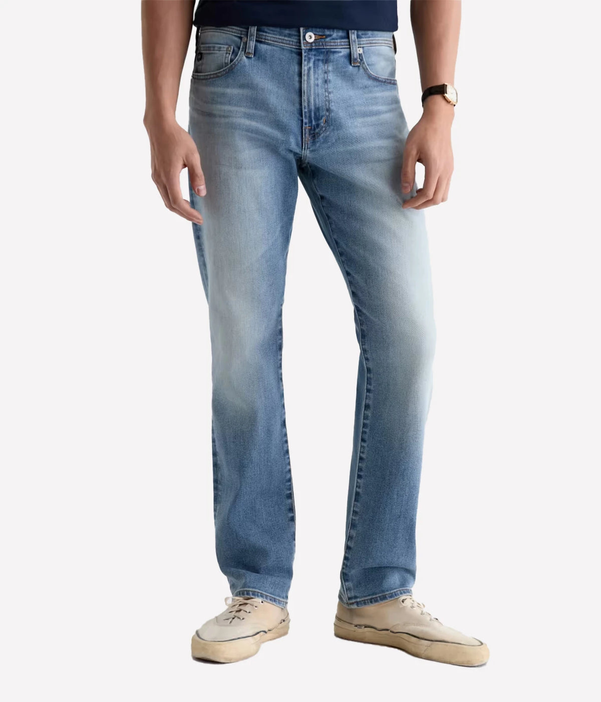Man wearing AG Everett Jean in Watkins with a navy T-shirt and off-white sneakers, angled front view