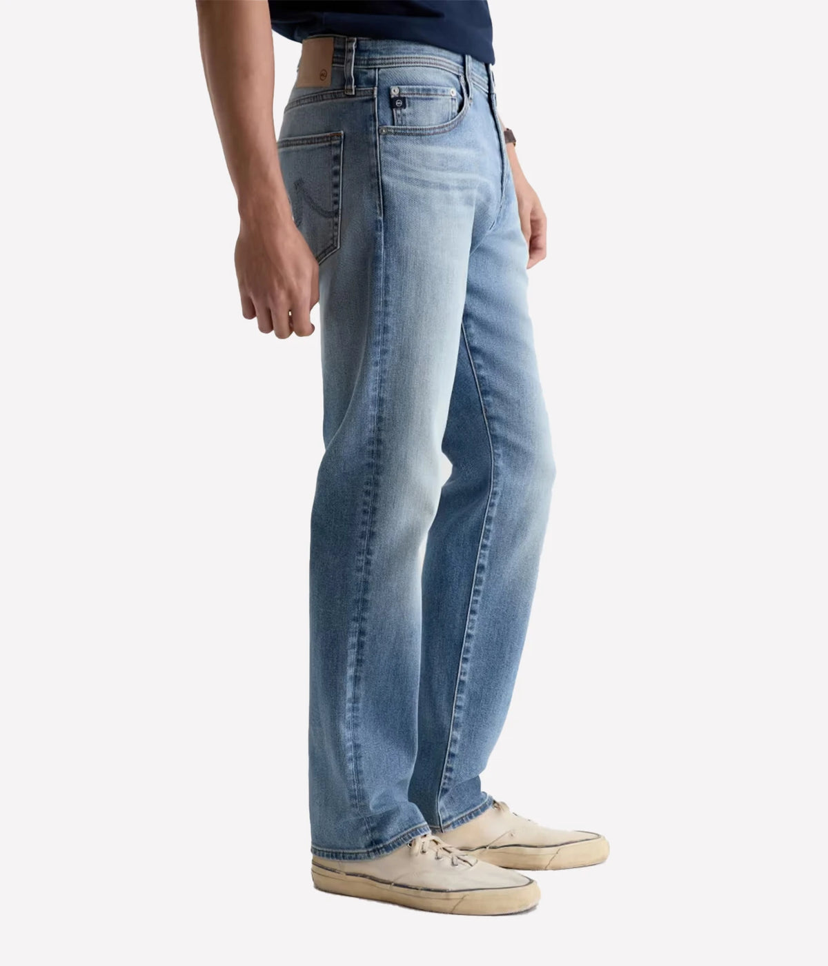 Man wearing AG Everett Jean in Watkins with off-white sneakers, side view