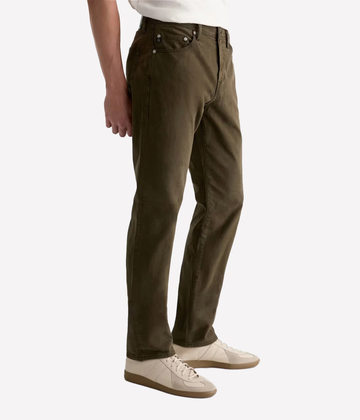 Man wearing AG Everett SUD Pant in Sulfur Dirty Olive with cream sneakers, side view