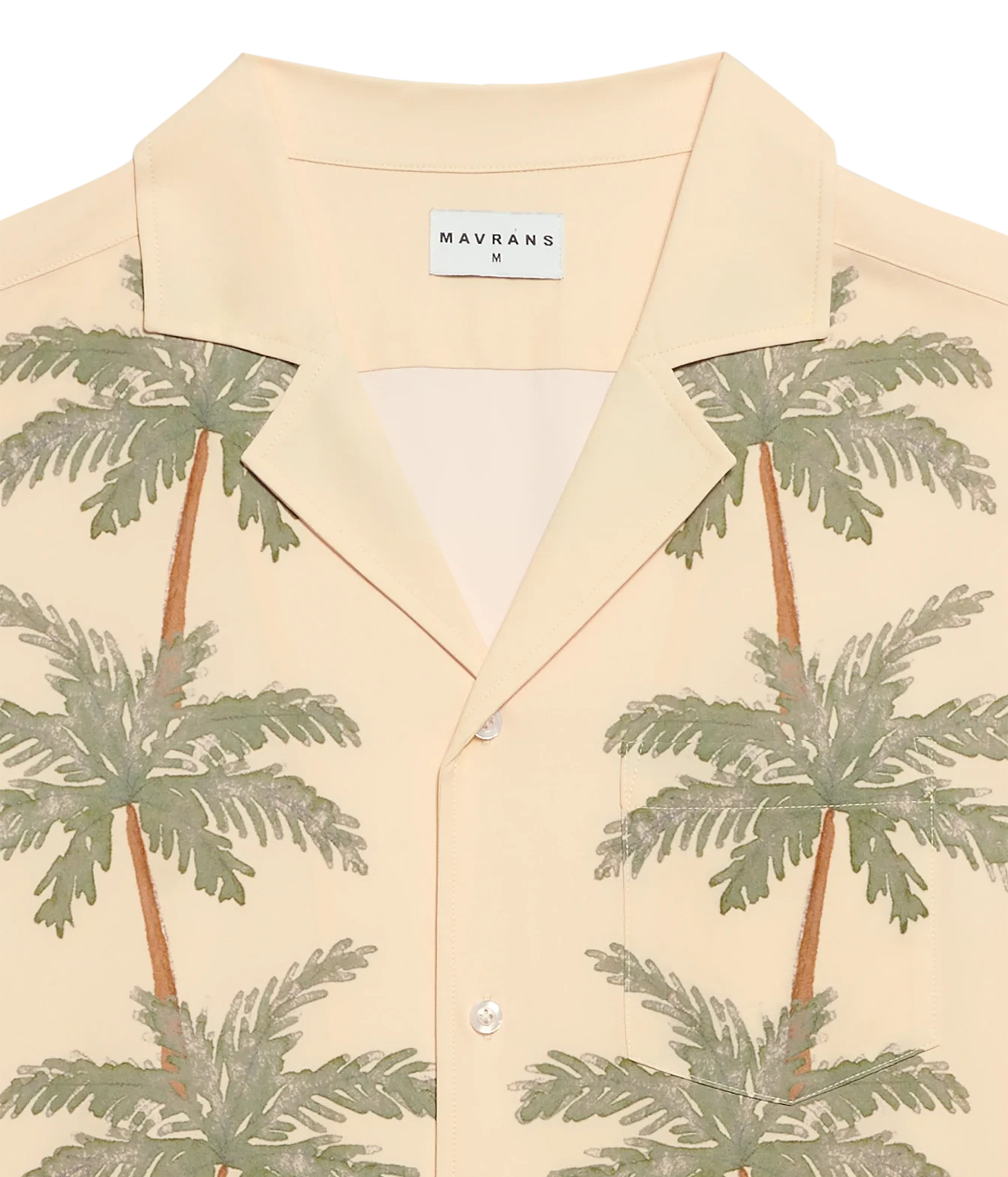 A close-up of a Mavrans men's short-sleeve button-up shirt in a light cream color, featuring a green palm tree print and a white brand label at the collar.