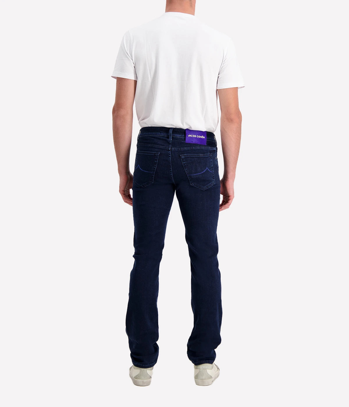 Men’s slim-fit jeans in dark blue-purple wash with five-pocket design, branded hardware, and suede patch.