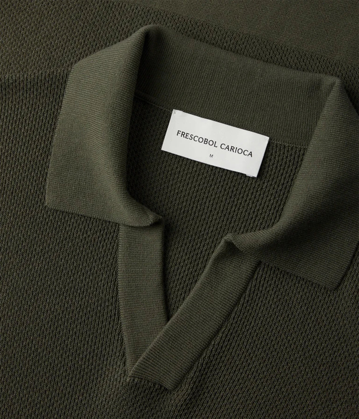 Close-up of a Frescobol Carioca Rino Short Sleeve Cotton Polo in Cove Green with a white neck label reading 'FRESCOBOL CARIACA'.