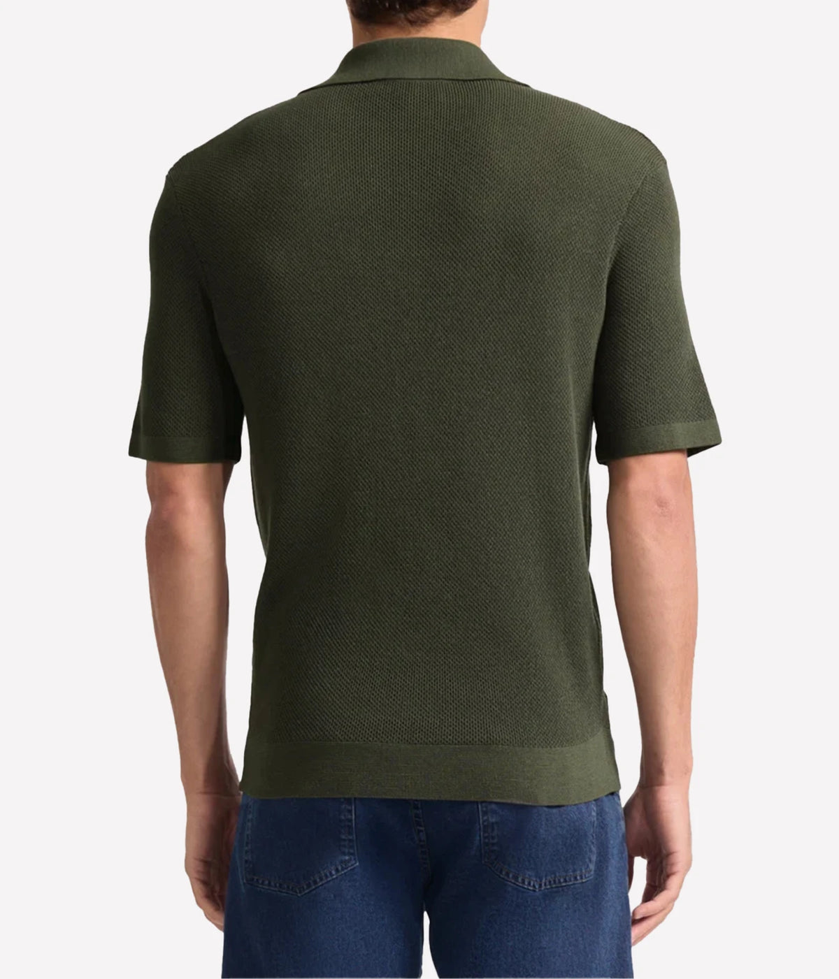 A man viewed from the back wearing a Frescobol Carioca Rino Short Sleeve Cotton Polo in Cove Green, paired with blue jeans, against a light grey studio background.