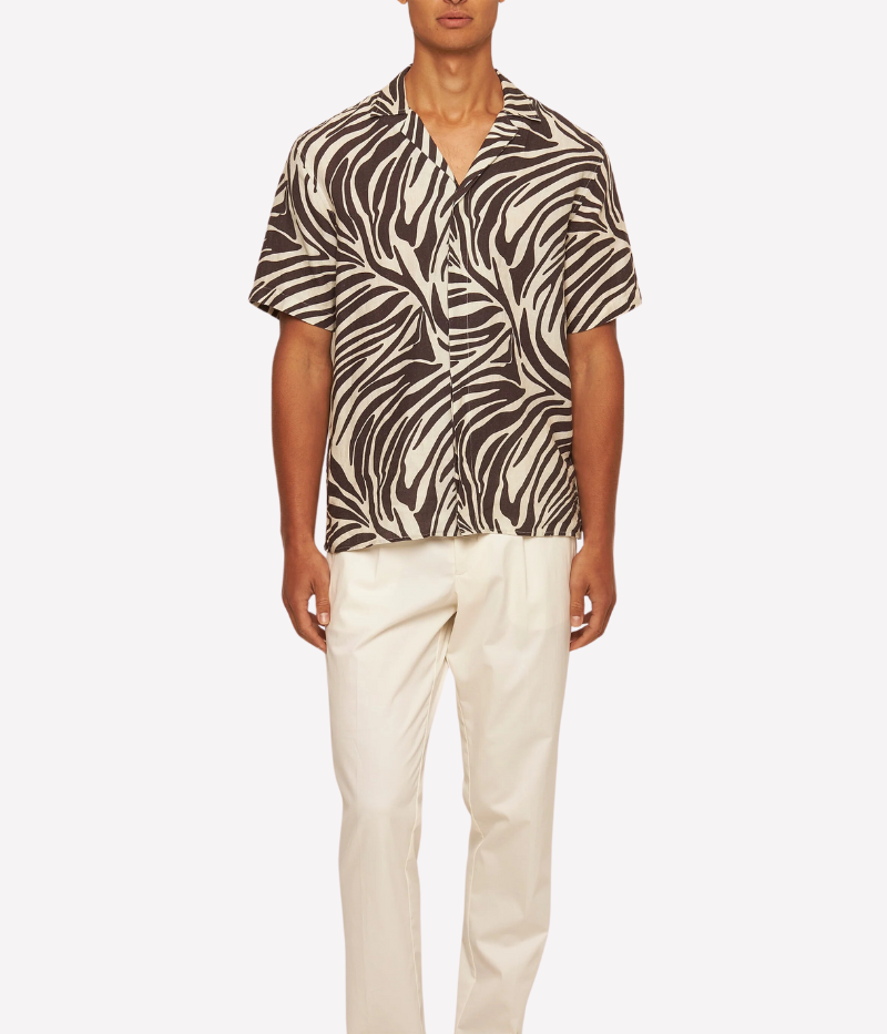 Orlebar Brown Maitan Shirt featuring bold brown zebra print inspired by Scaramanga in The Man with the Golden Gun. Relaxed fit with Capri collar, concealed button placket, branded imitation mother-of-pearl buttons, and back pleats. Made from 100% linen with side seam hem split