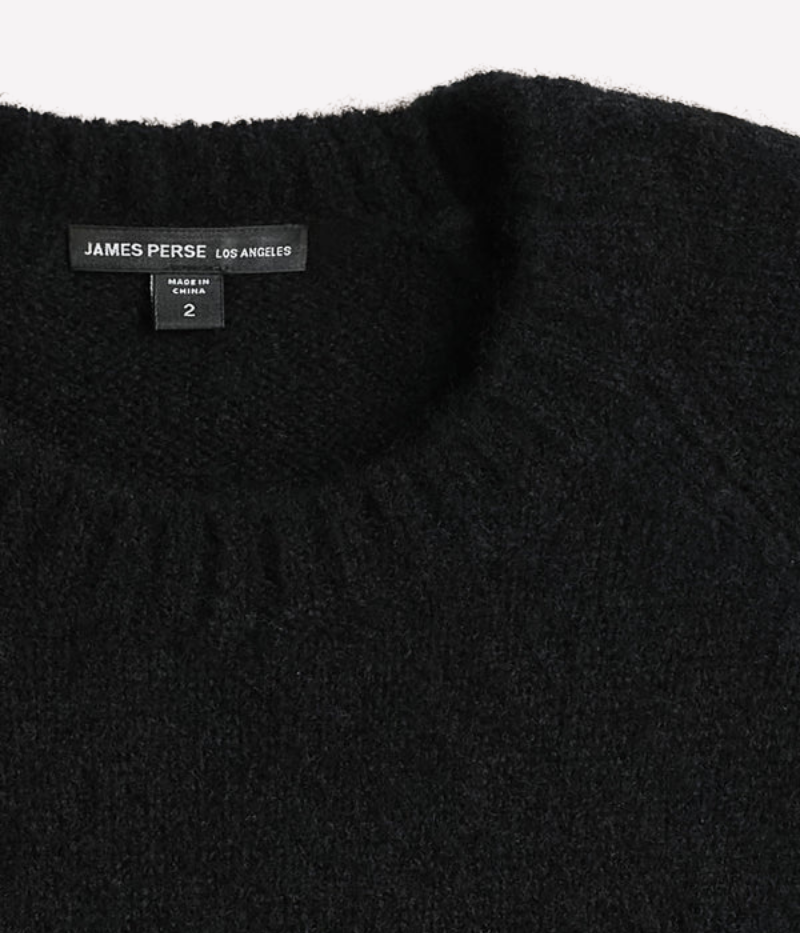 A lightweight, true black cashmere crewneck sweater featuring ribbed detailing at the neckline, cuffs, and hem for a classic and polished appearance.
