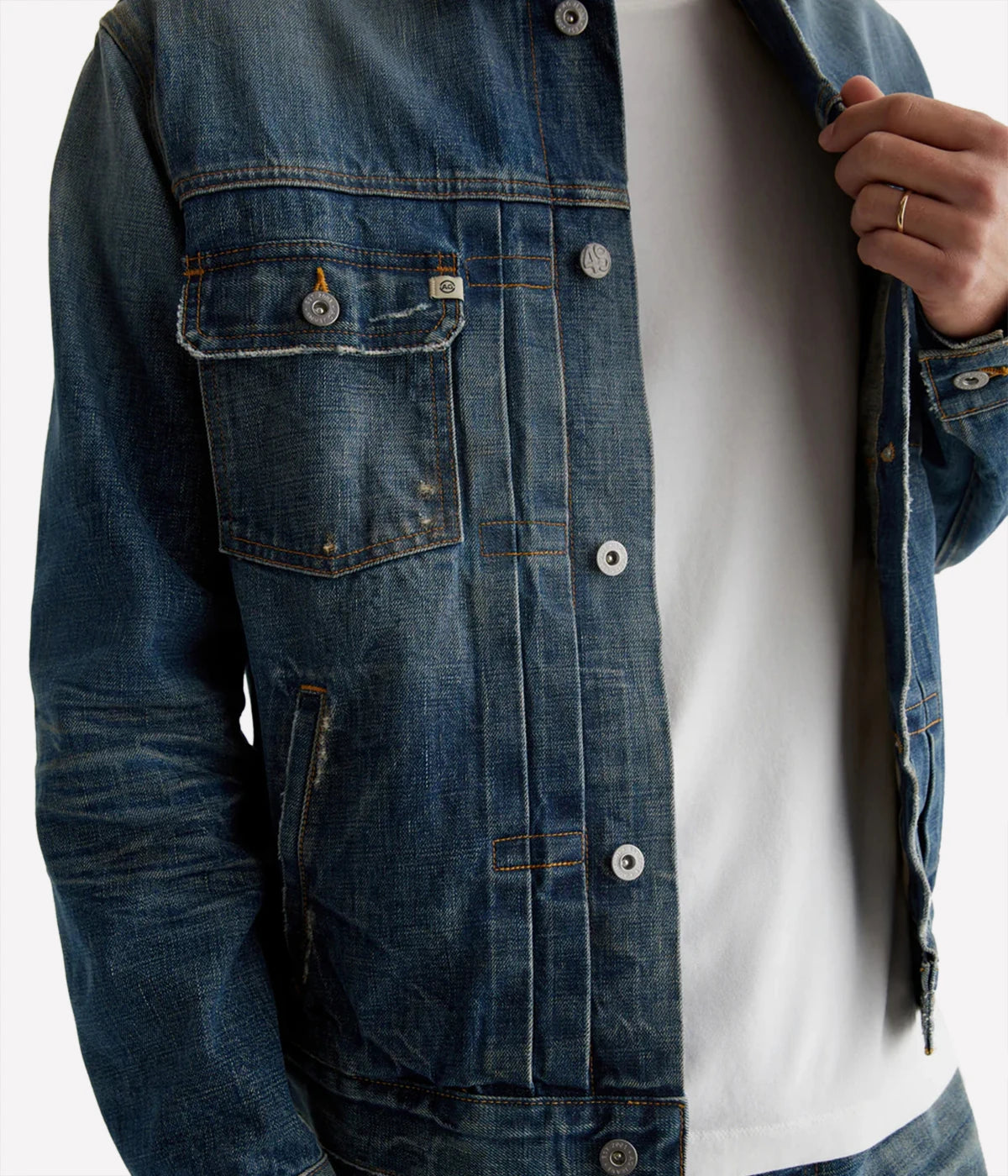 Classic trucker jacket made from premium Japanese selvage denim, featuring pleated front detailing and an authentic vintage wash with subtle distressing. Adjustable back tabs for a custom fit. Material: 100% Cotton. Made in USA.