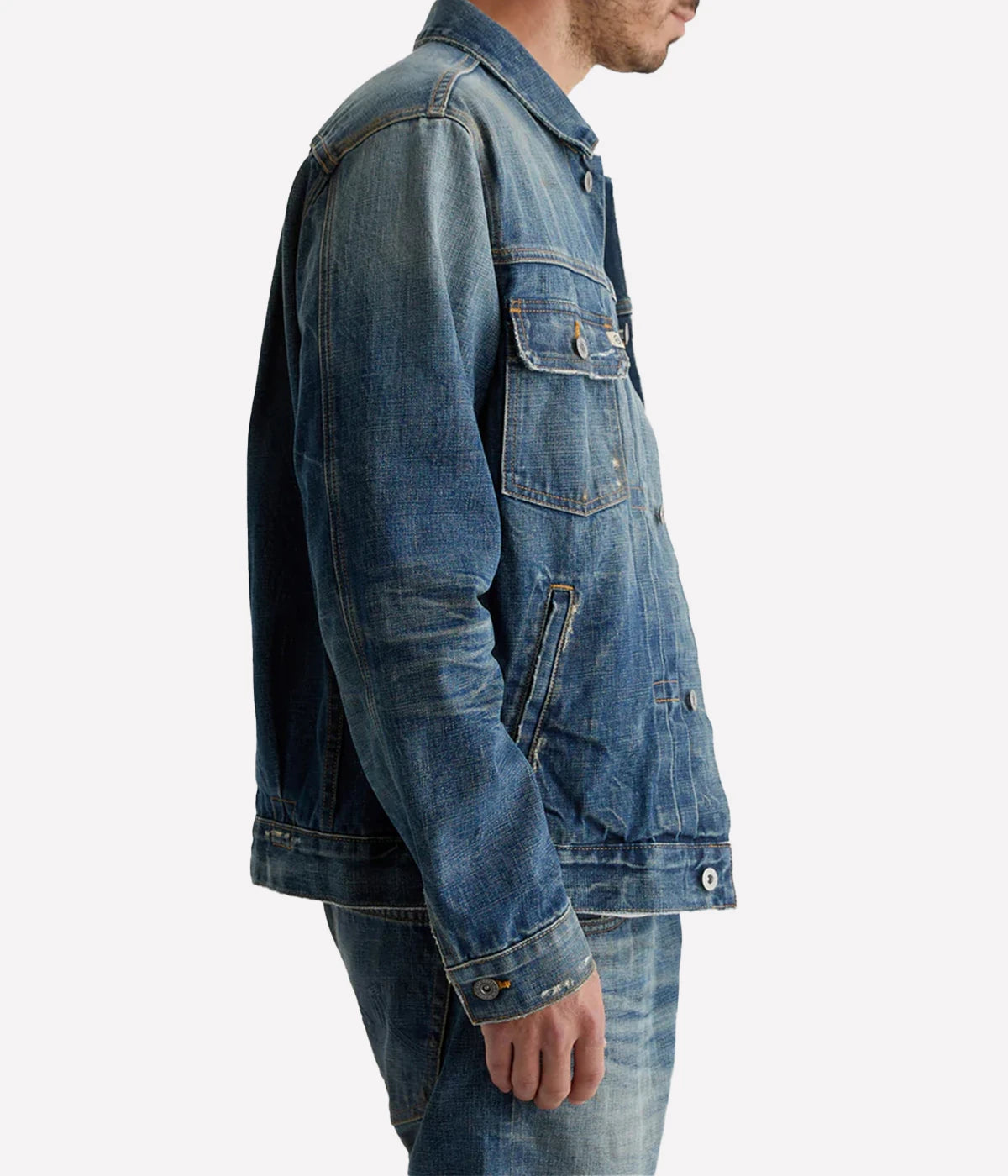 Classic trucker jacket made from premium Japanese selvage denim, featuring pleated front detailing and an authentic vintage wash with subtle distressing. Adjustable back tabs for a custom fit. Material: 100% Cotton. Made in USA.
