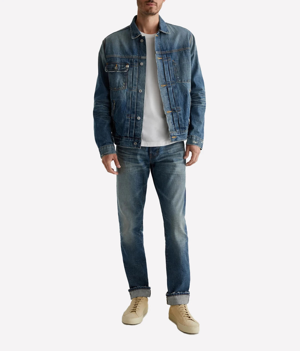 Classic trucker jacket made from premium Japanese selvage denim, featuring pleated front detailing and an authentic vintage wash with subtle distressing. Adjustable back tabs for a custom fit. Material: 100% Cotton. Made in USA.