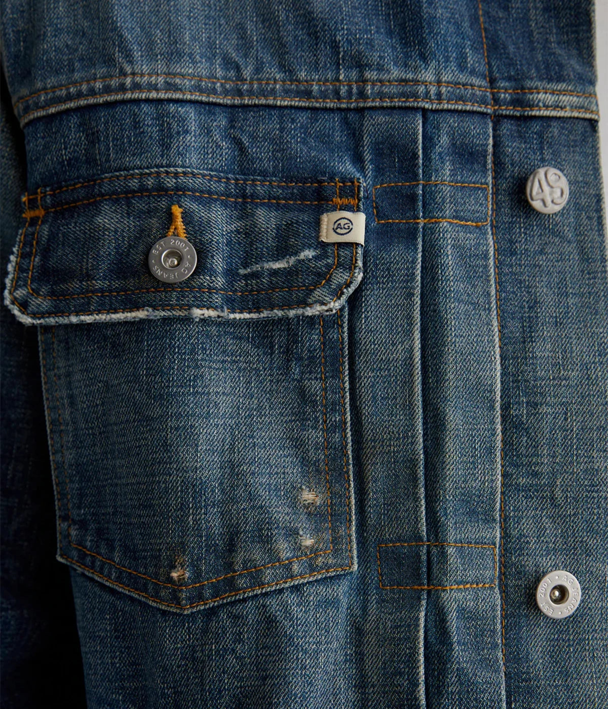 Classic trucker jacket made from premium Japanese selvage denim, featuring pleated front detailing and an authentic vintage wash with subtle distressing. Adjustable back tabs for a custom fit. Material: 100% Cotton. Made in USA.