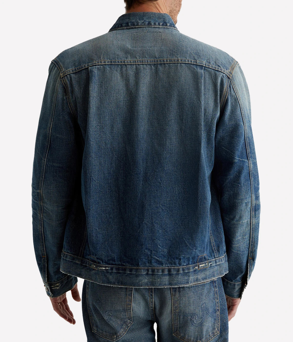Classic trucker jacket made from premium Japanese selvage denim, featuring pleated front detailing and an authentic vintage wash with subtle distressing. Adjustable back tabs for a custom fit. Material: 100% Cotton. Made in USA.