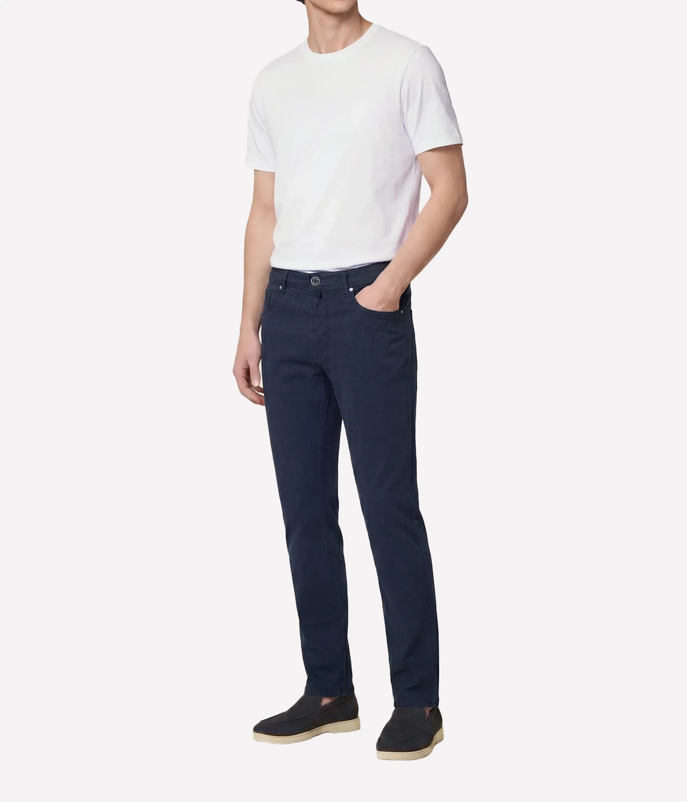 Person wearing a white t-shirt and dark jeans on a white background