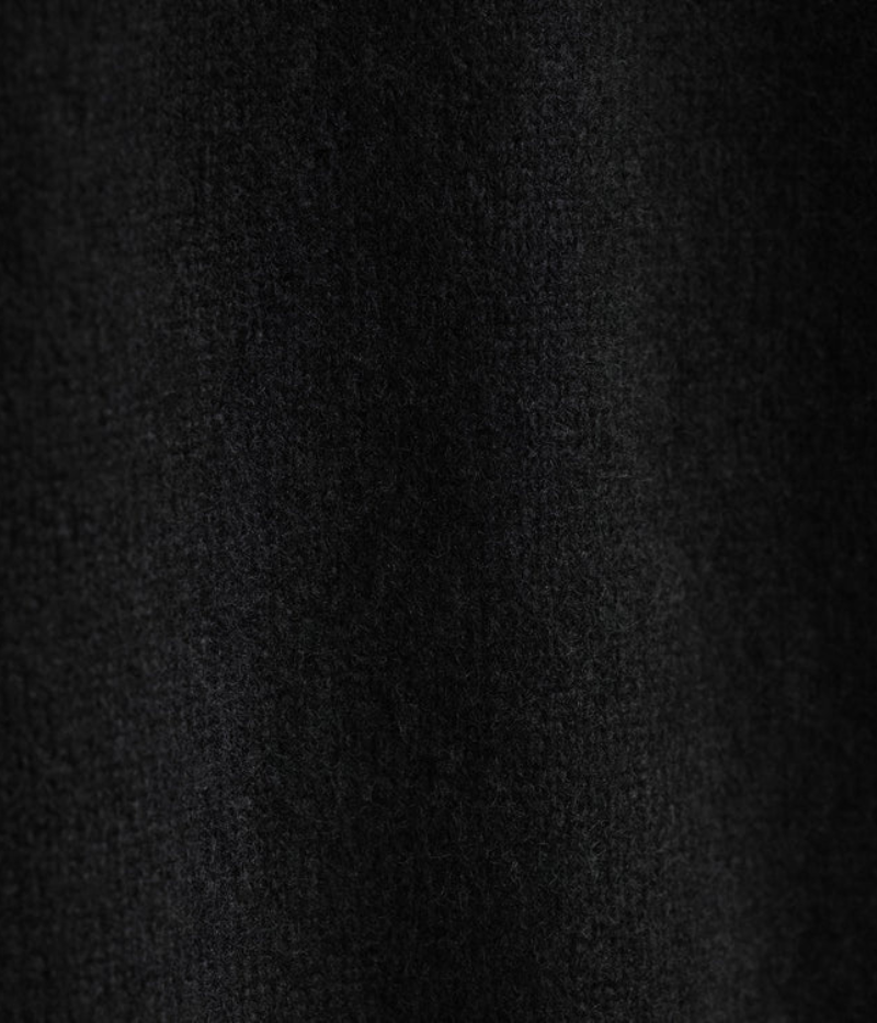 A lightweight, true black cashmere crewneck sweater featuring ribbed detailing at the neckline, cuffs, and hem for a classic and polished appearance.