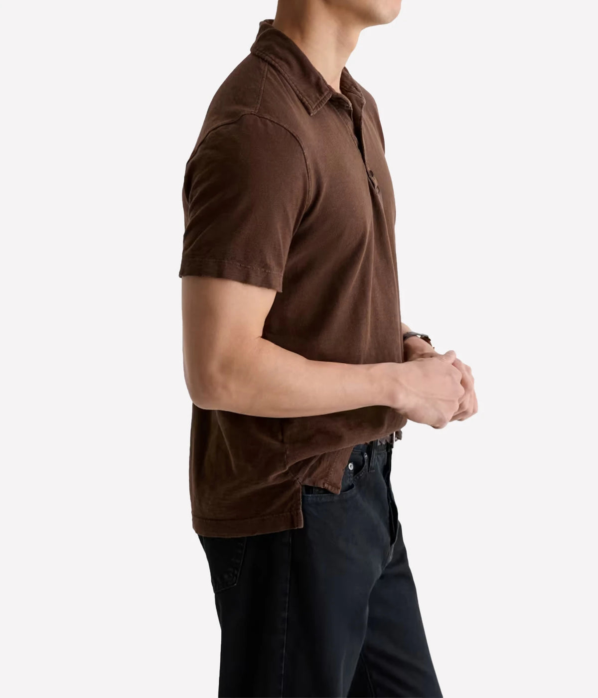 Man wearing AG Bryce Short Sleeve Polo in Sulfur Wood Brown with dark jeans, side view