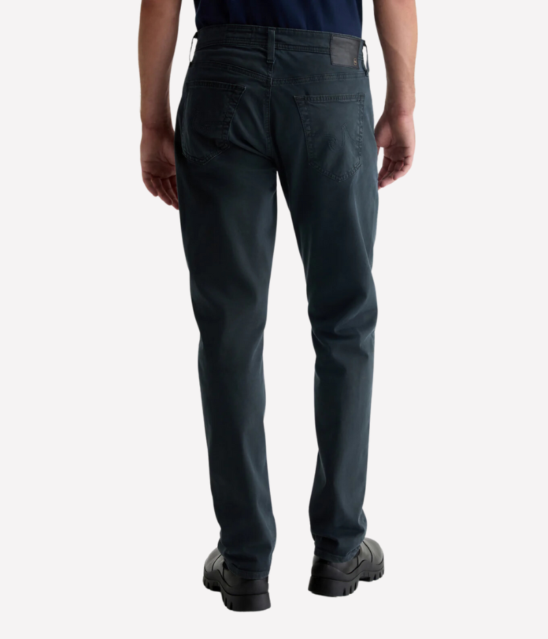 AG's Everett slim-straight men's pants in dark grey, crafted from 8.4 oz. Sueded Stretch Sateen from Italy. Featuring a mid-rise waist and a straight fit relaxed from hip to knee with a slight taper at the leg opening. Detailed measurements include a 10 1/4" front rise, 16 1/2" knee opening, 15" bottom opening, and 34" inseam.