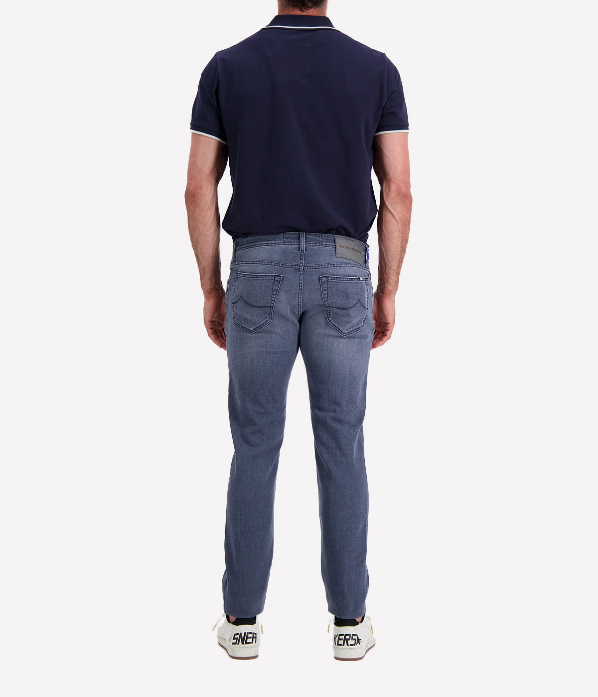 Jacob Cohen Bard 5 Pocket Slim Jeans in a washed blue finish, featuring a modern slim fit, classic five-pocket styling, and contrast stitching. Styled with a navy tee and white sneakers for a casual yet polished look.