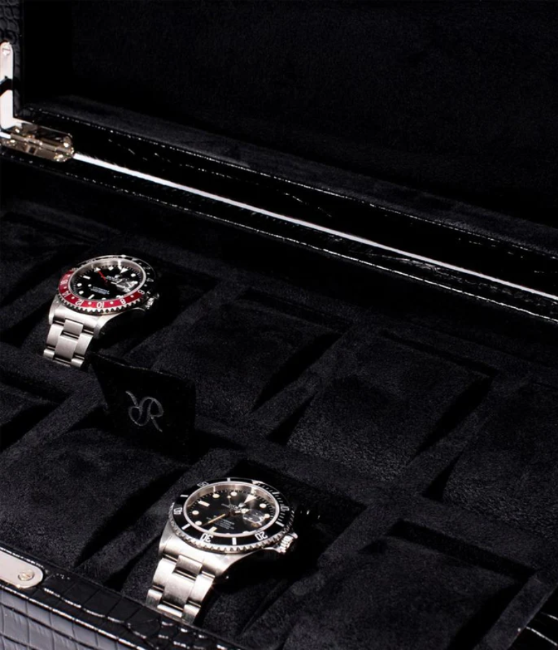 The Brompton Watch Box is meticulously handcrafted from solid wood and wrapped in luxurious black crocodile-pattern leather. Designed to hold up to ten watches, it features a plush suede-lined interior and adjustable cushions to securely fit timepieces of all sizes. A sophisticated storage solution for protecting and displaying your watch collection.
