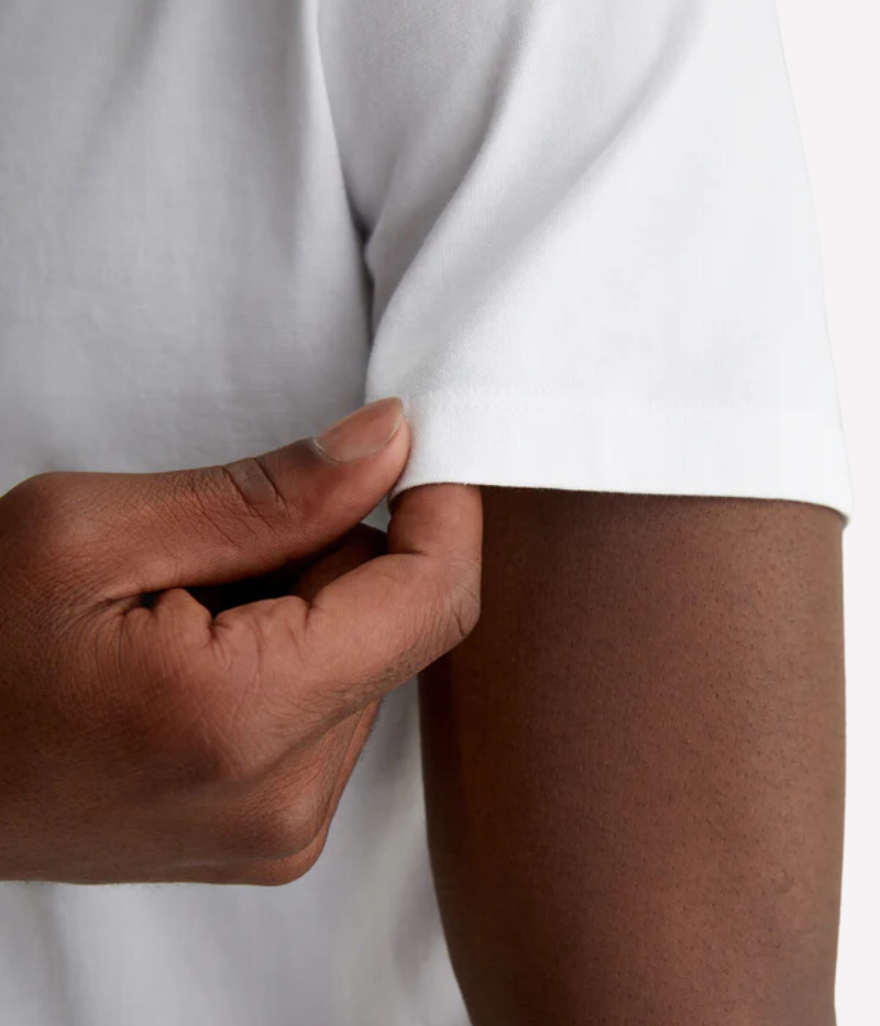 Close-up of the ribbed V-neckline on the Bryce white tee, adding subtle texture to the soft cotton fabric.