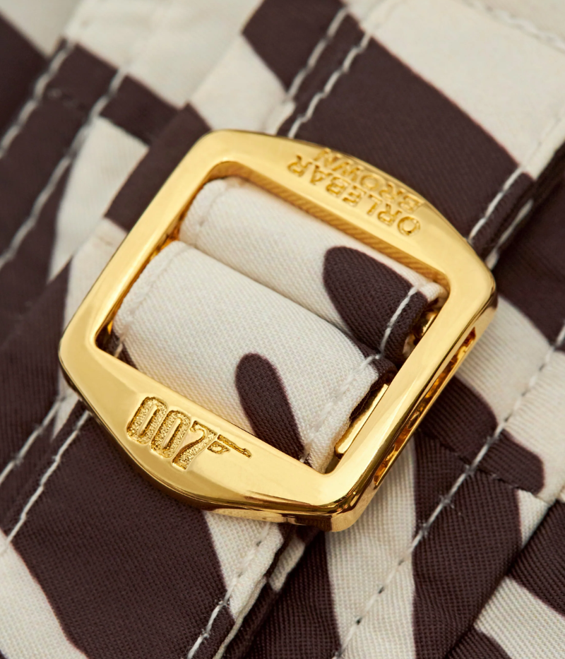 Close-up of the gold-tone side adjusters and snap closure on the Orlebar Brown Bulldog Golden Gun Zebra Swim Shorts, inspired by Scaramanga's iconic golden bullet.