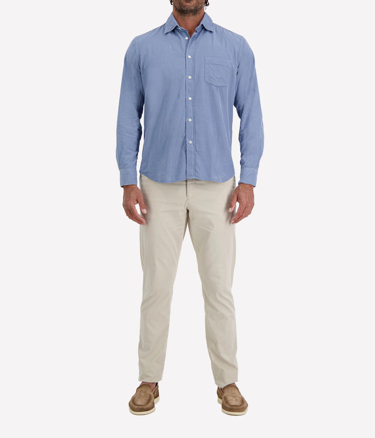 Man wearing Hartford Paul Fine Corduroy Shirt in Chambray Blue with stone chinos and brown suede shoes, full-length front view