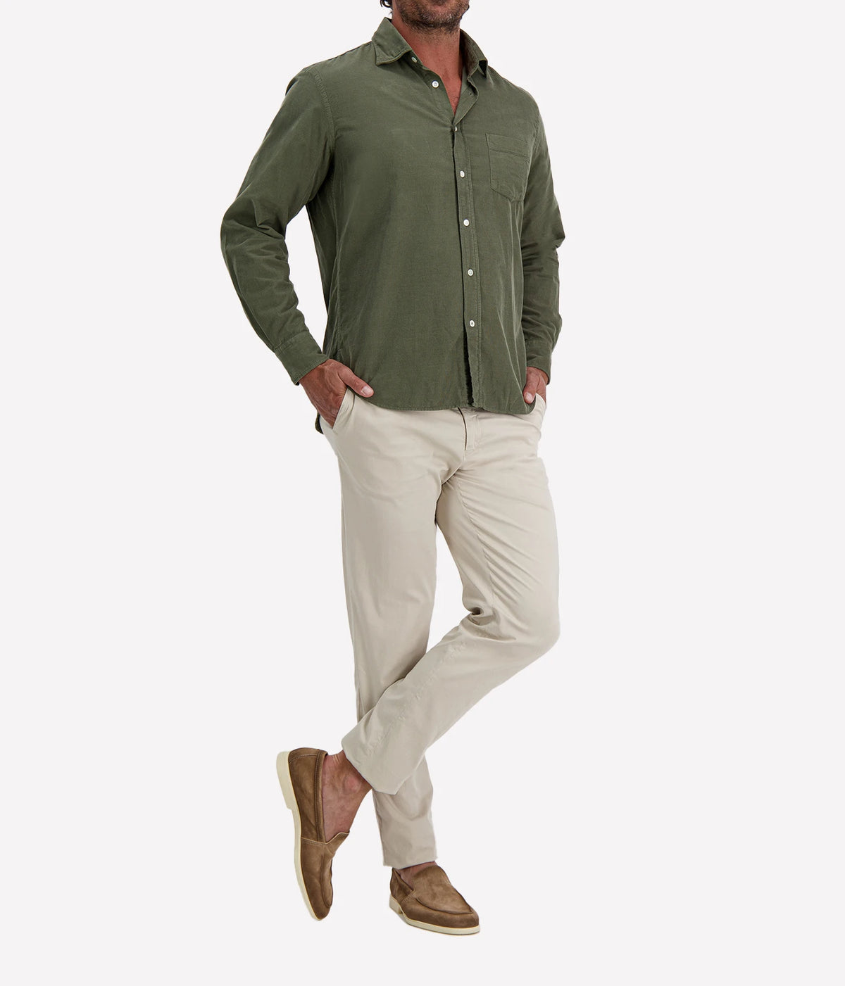 Man wearing Hartford Paul Fine Corduroy Shirt in Military with stone chinos and brown suede shoes, angled front view with hand in pocket