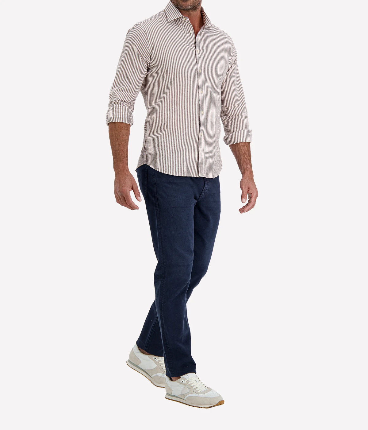 Man wearing Ingram Slim Fit Shirt in Seersucker Brown & White Stripe with indigo jeans and white sneakers, angled front view