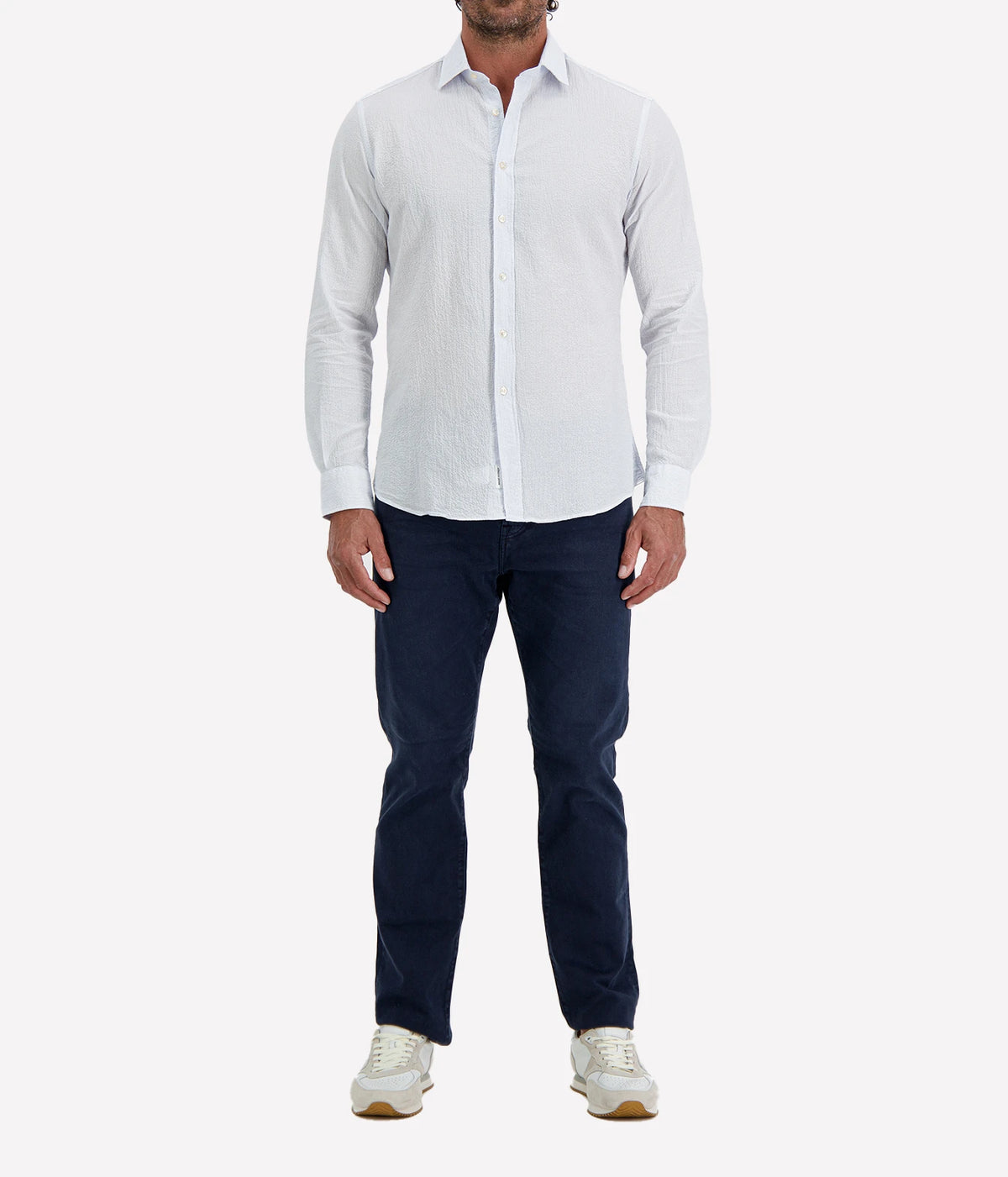 Man wearing Ingram Slim Fit Shirt in Seersucker Blue & White Stripe with indigo jeans and white sneakers, full-length front view