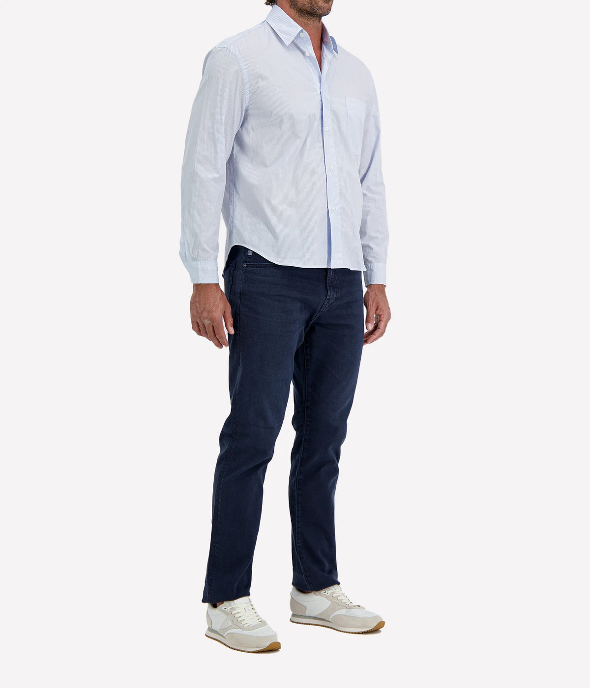 Man wearing Lardini Cotton Pocket Shirt in Blue Stripe with indigo jeans and white sneakers, three-quarter view