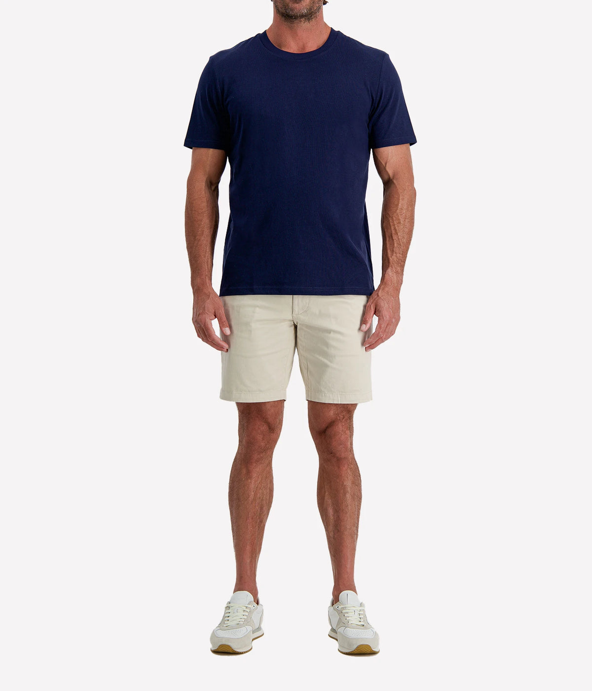 Man wearing Calexico Man Jamie Tee in Navy with stone shorts and white sneakers, full-length front view
