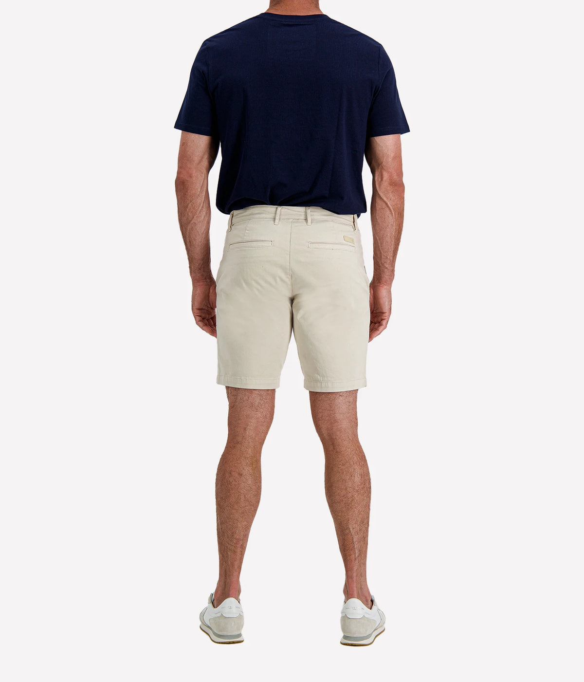 Man wearing AG Wanderer Short in Pumice with a navy T-shirt and white sneakers, front view