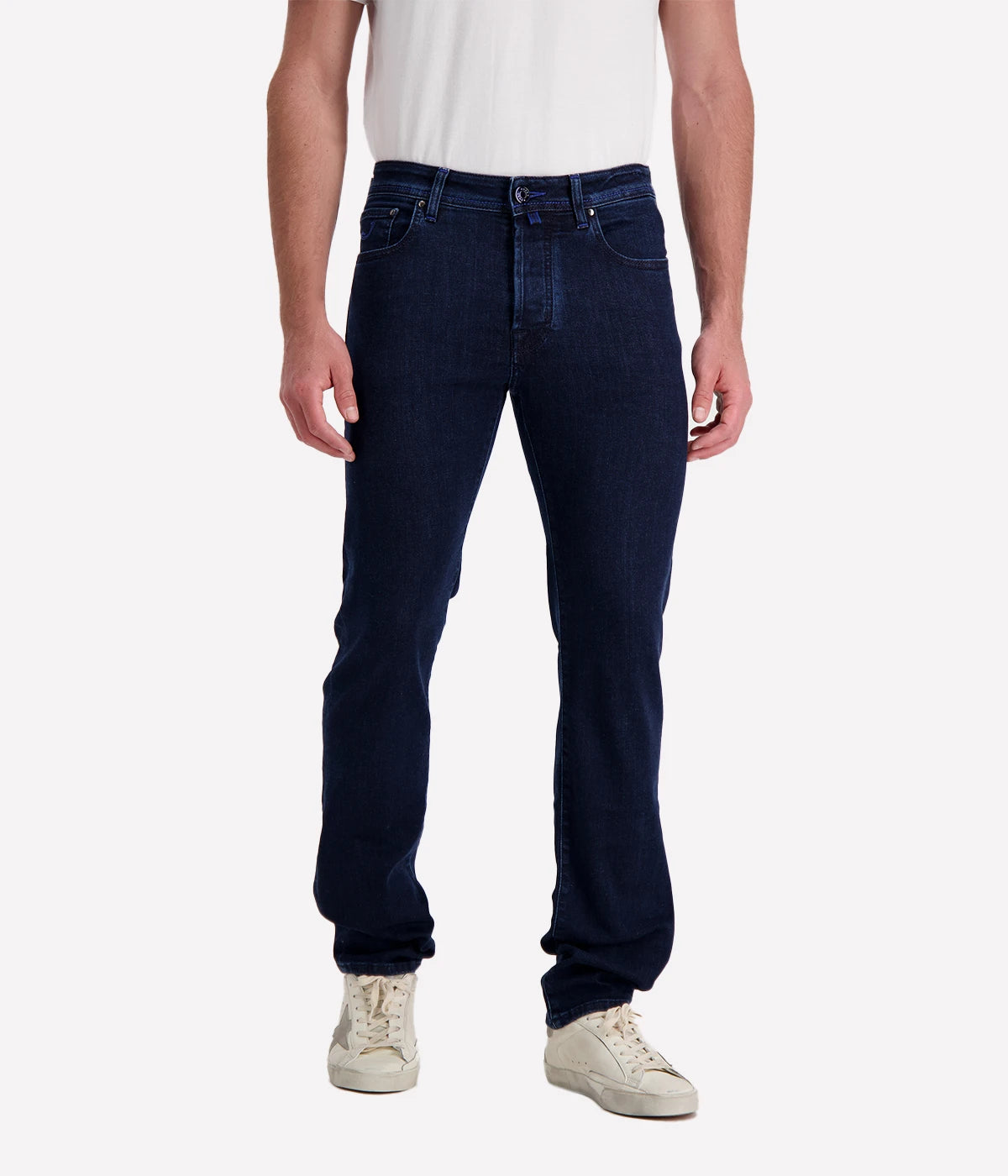 Men’s slim-fit dark blue jeans with five-pocket design, branded hardware, and suede patch.