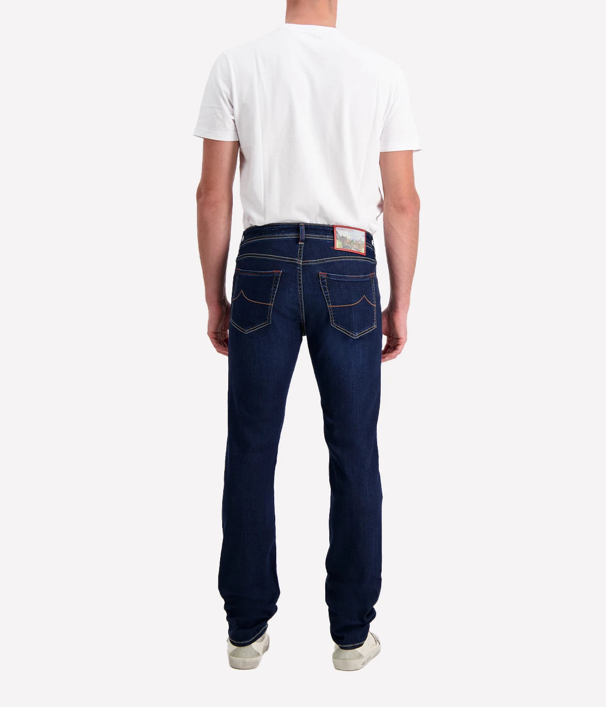 Men’s slim-fit dark blue jeans with five-pocket design, branded hardware, and suede patch.
