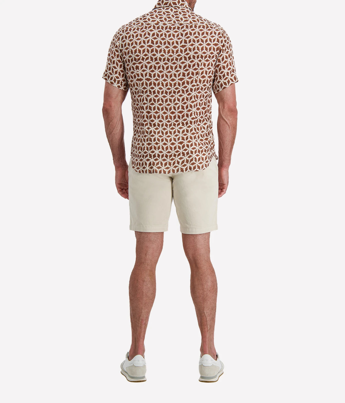 Back view of man wearing Osvaldo Trucchi Linen Short Sleeve Shirt in Brown Geo Star Print with stone shorts