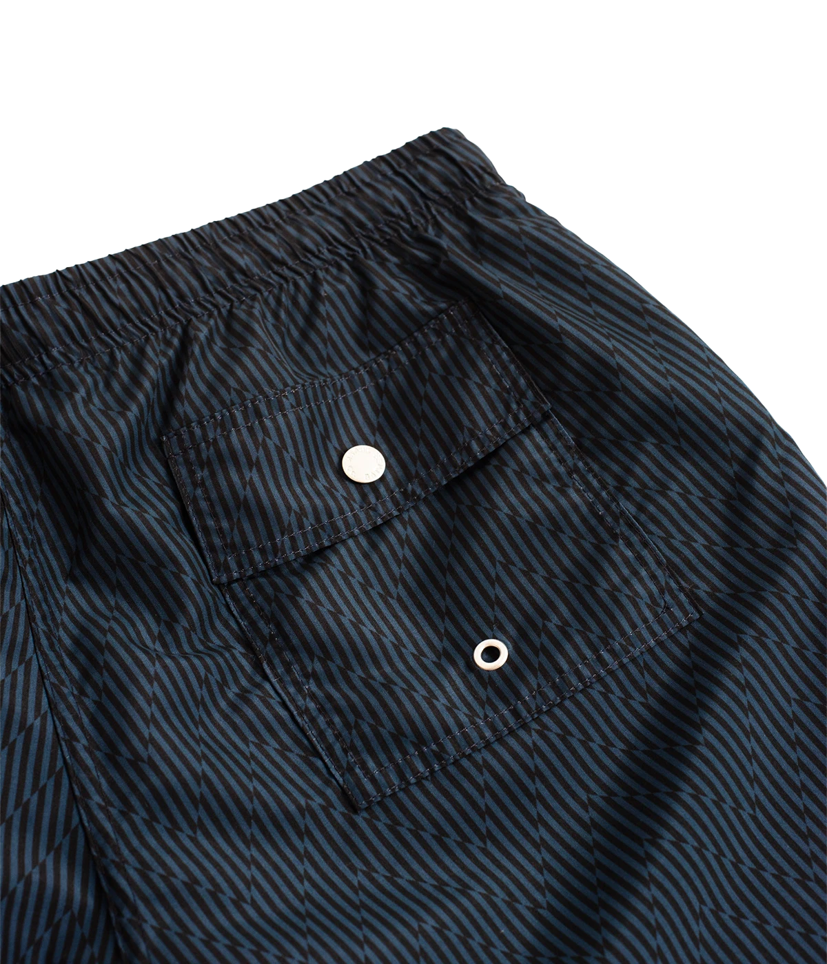Bather’s geometric swim trunks feature a bold, monochromatic herringbone-inspired pattern, reminiscent of retro ‘60s design. With a 5.5” inseam, reinforced pockets, and a back snap pocket, these quick-dry swim shorts are crafted from 100% recycled polyester for a stylish and sustainable fit.