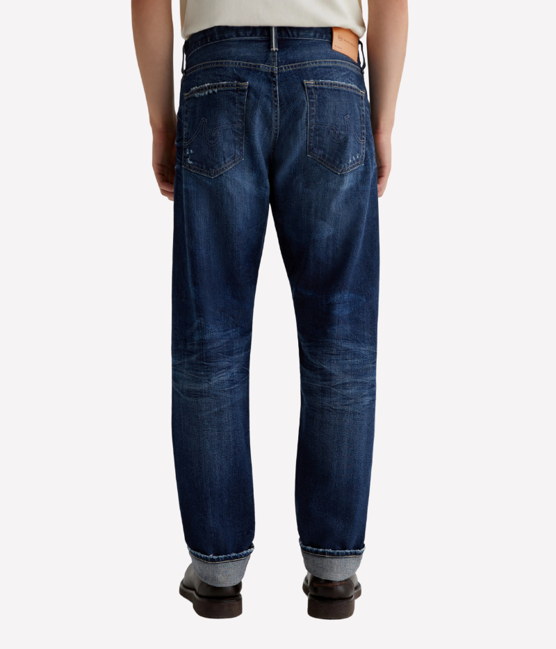 AG Everett slim straight Japanese selvage jeans in dark indigo wash with fading and whiskering, made from non-stretch denim.