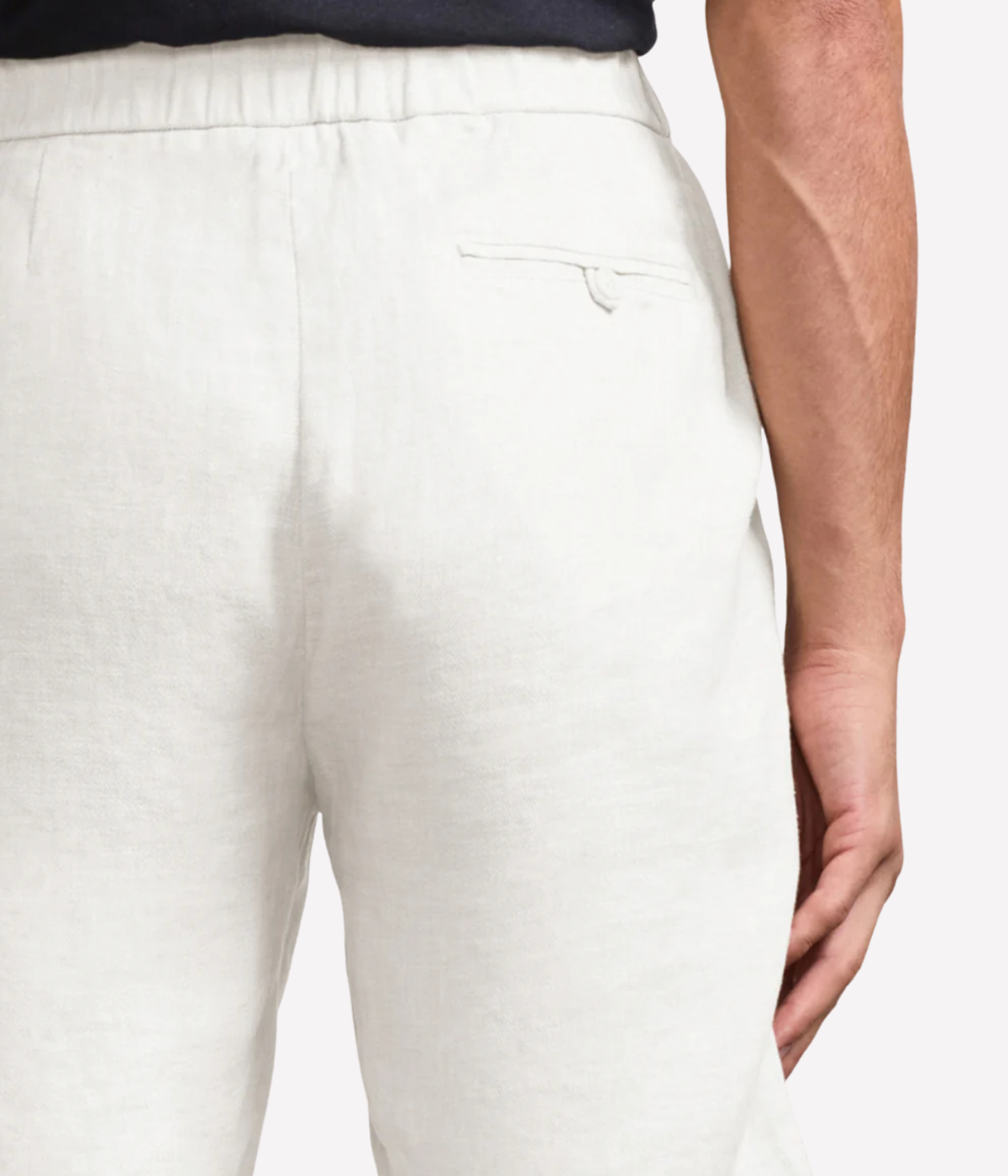 White pants worn by a person on a plain background