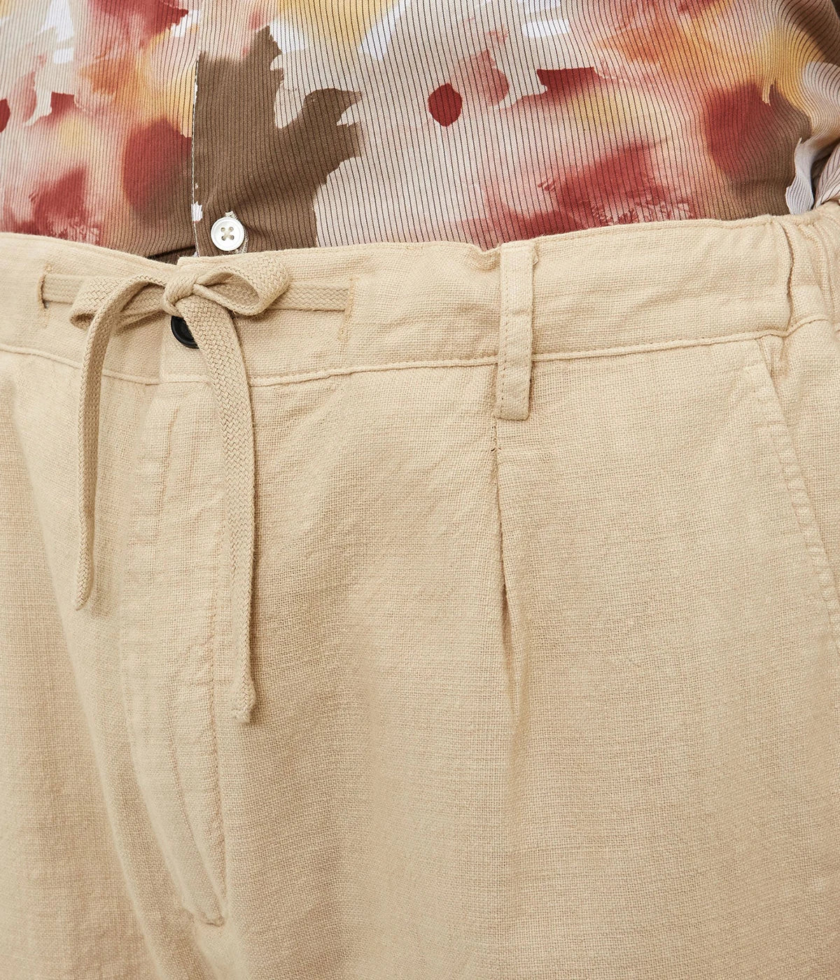 Men's comfort-fit cotton gauze trousers with pleats, elastic waistband, and slant pockets.