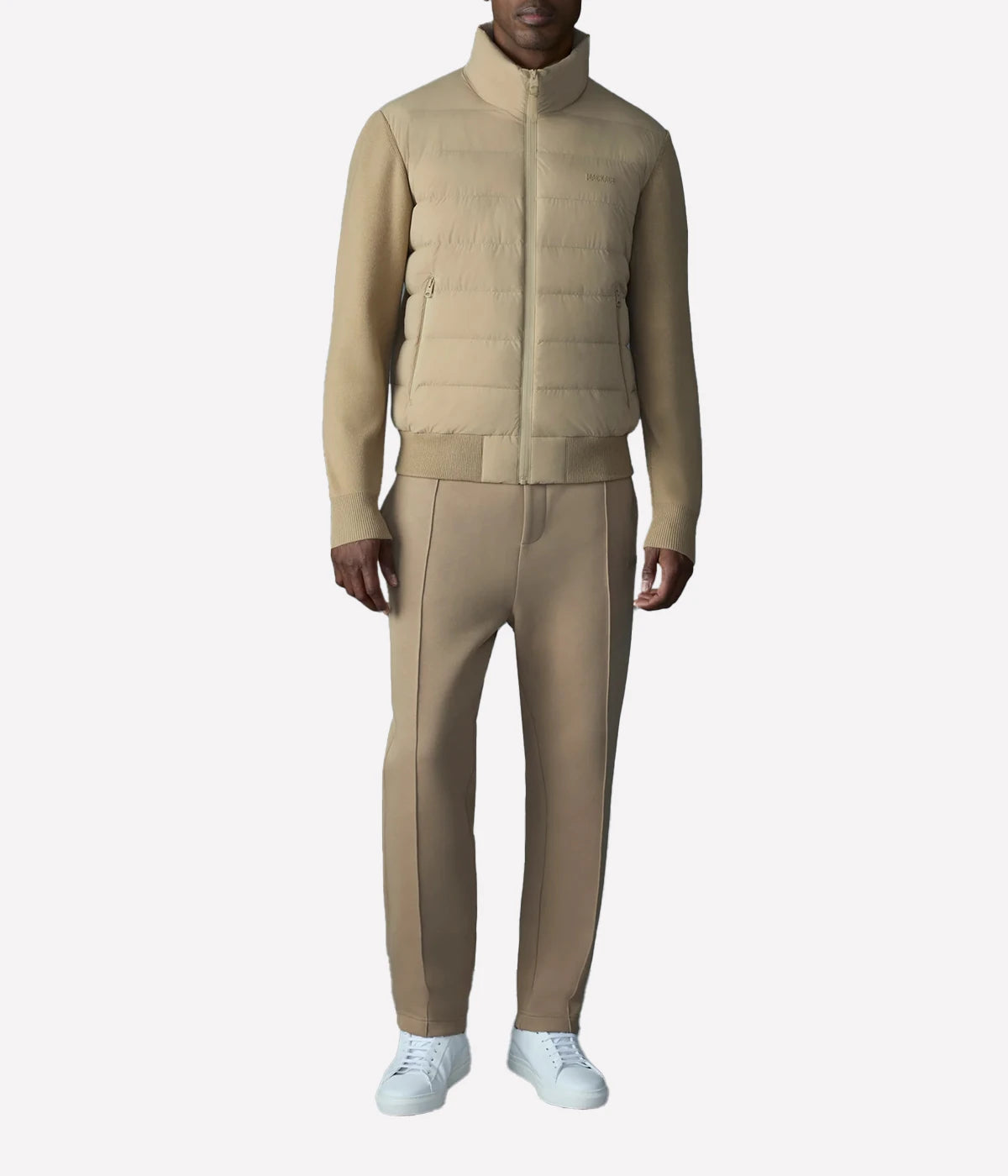 Hybrid down vest with stretch-knit body, ribbed trims, zip pockets, and subtle logo detail.