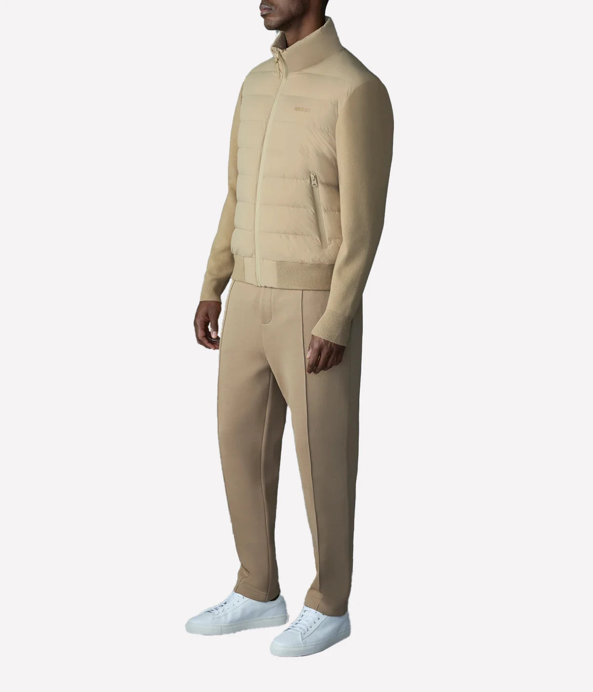 Hybrid down vest with stretch-knit body, ribbed trims, zip pockets, and subtle logo detail.