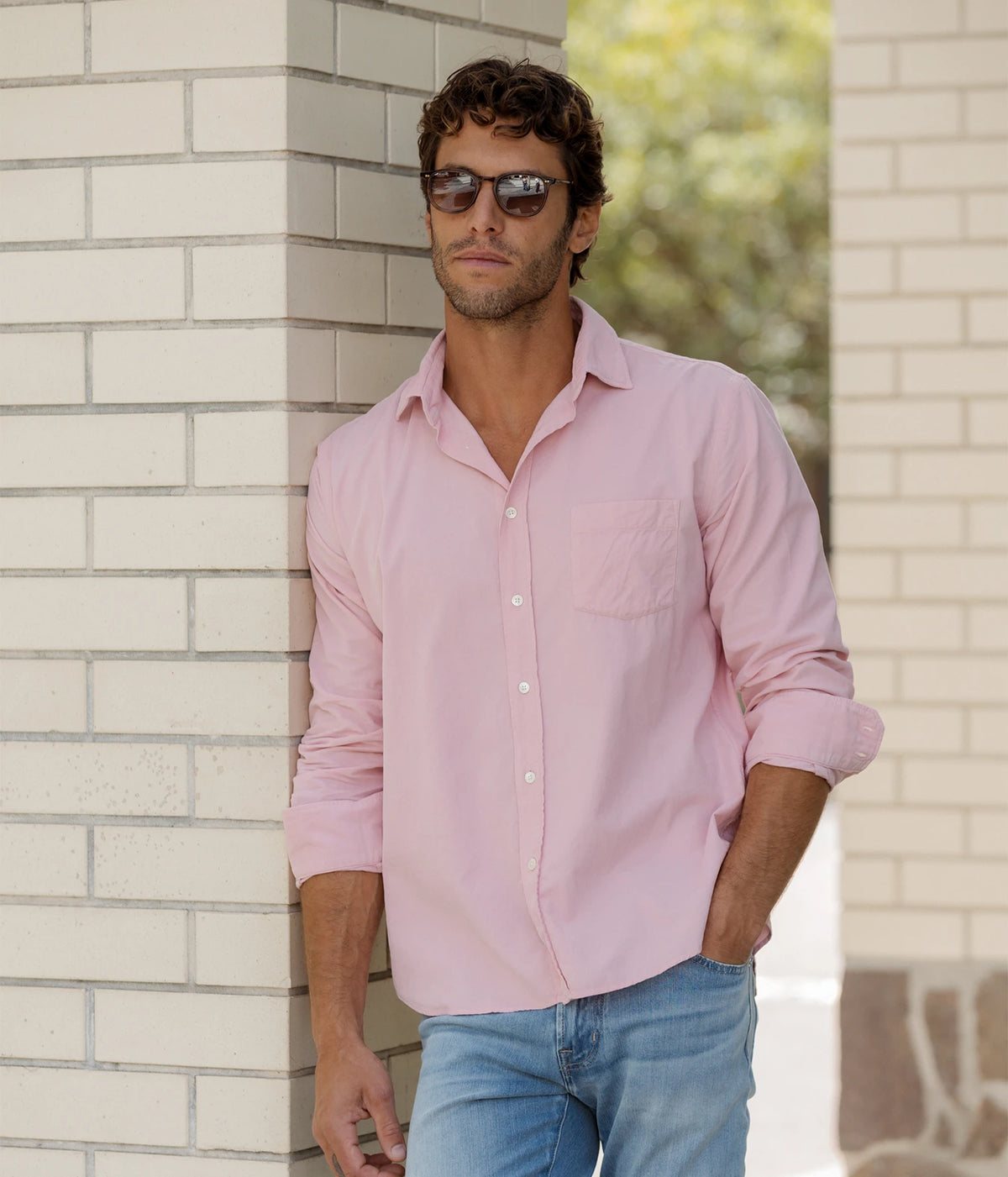 Man wearing Hartford Paul Fine Corduroy Shirt in Old Pink with light blue jeans, standing against a wall, front view
