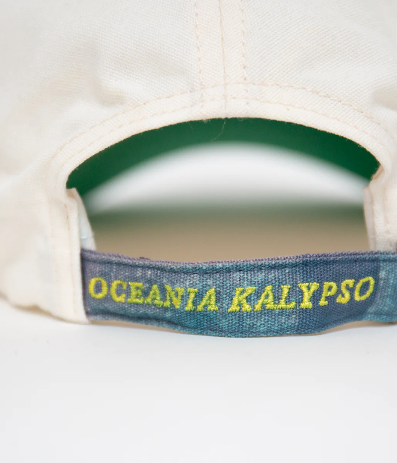 Nick Fouquet anchor crest cap – natural/blue potassium-sprayed canvas with embroidered anchor on front and "Oceania Kalypso" on strap.