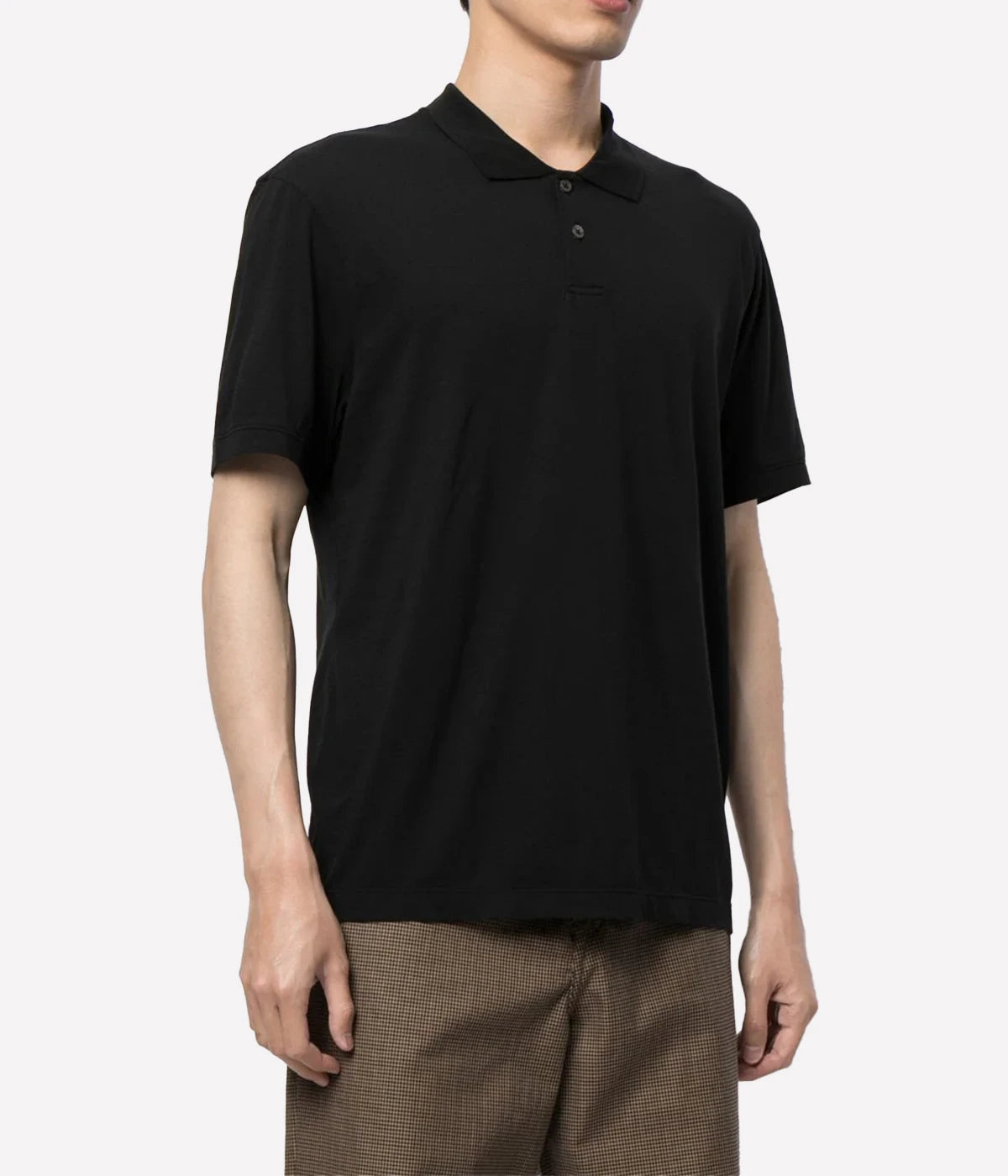 An on model shot showing the relaxed fit of the Luxe Lotus Jersey Polo. Polished black top made of lightweight, comfortable fabric.