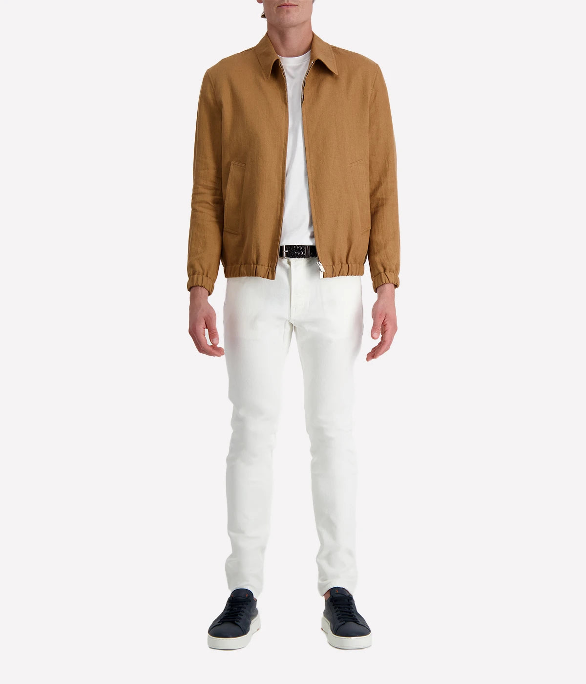 Man wearing a tan Lardini linen jacket with a zip front, elasticated hem and cuffs, and a shirt collar, styled with a white tee and white trousers.