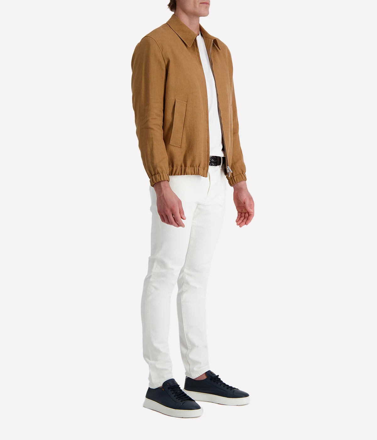Man wearing a tan Lardini linen jacket with a zip front, elasticated hem and cuffs, and a shirt collar, styled with a white tee and white trousers.
