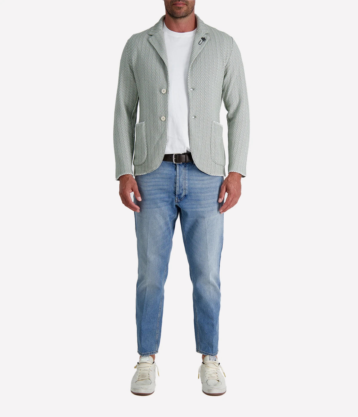 A green and white Lardini knit jacket with a herringbone pattern, soft unstructured fit, and signature floral lapel pin, made from 100% cotton, styled with a white t-shirt and jeans.