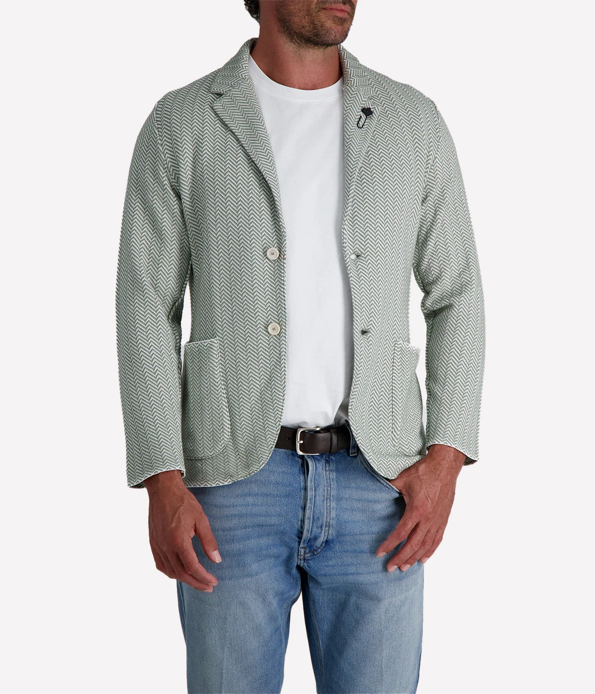 A green and white Lardini knit jacket with a herringbone pattern, soft unstructured fit, and signature floral lapel pin, made from 100% cotton, styled with a white t-shirt and jeans.