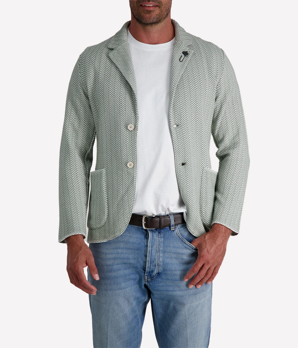 A green and white Lardini knit jacket with a herringbone pattern, soft unstructured fit, and signature floral lapel pin, made from 100% cotton, styled with a white t-shirt and jeans.