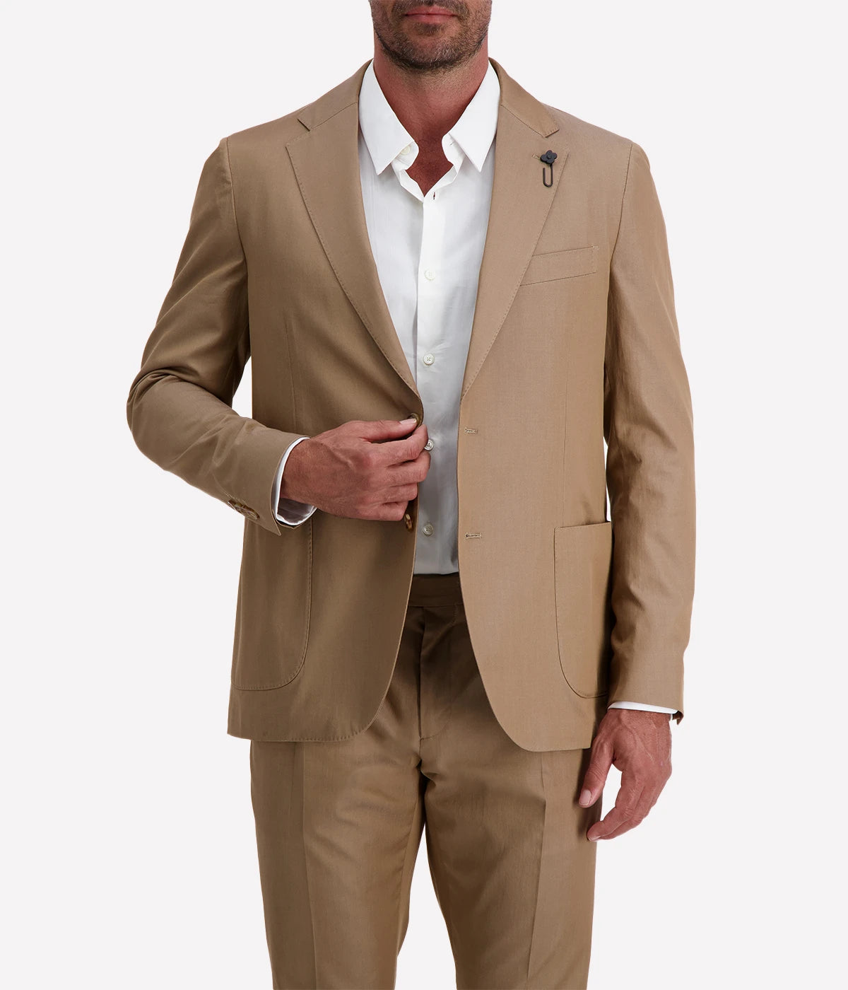 Model wearing a light brown Lardini cotton suit with a white shirt and suede loafers, featuring a single-breasted blazer with Lardini’s signature boutonnière, styled outdoors in a relaxed, modern setting.