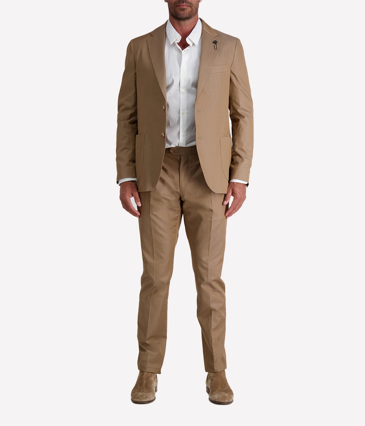 Model wearing a light brown Lardini cotton suit with a white shirt and suede loafers, featuring a single-breasted blazer with Lardini’s signature boutonnière, styled outdoors in a relaxed, modern setting.