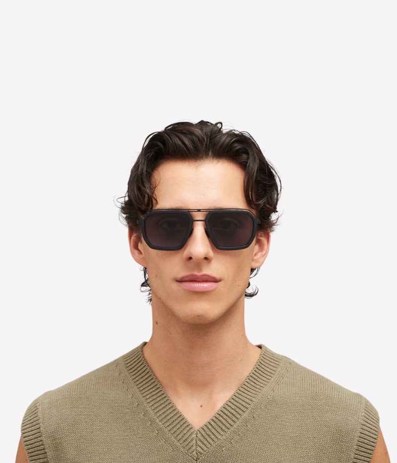 A model wearing the Mojave Sun MH6 sunglasses in Black Cool Grey, styled with a relaxed outfit. The circular frame and hybrid design offer a modern yet understated look, perfect for lightweight comfort and all-day wear.
